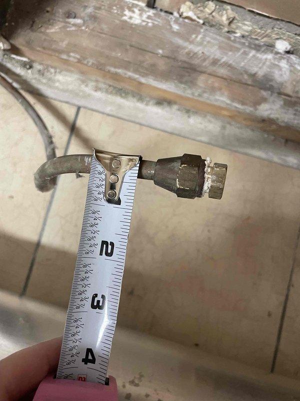 Provided estimate for replacement of 40-year-old natural gas wall furnace unit located in garage/laundry room. Existing unit is operational but has reached end of service life. Documented current installation including exposed wall cavity with deteriorated backing panel, flexible ductwork configuration on tile floor, and gas line connections with threaded fittings showing oxidation and age-related wear.