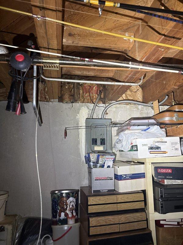 Completed comprehensive electrical inspection of residential basement electrical panel and associated wiring systems. Evaluated panel condition, circuit loading, wire routing through floor joists, and proper securing of conductors with appropriate fasteners. Assessed conduit connections, grounding systems, and overall code compliance of the electrical installation in the unfinished basement utility area.