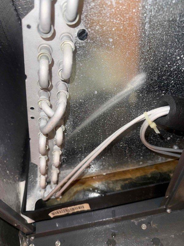 Responded to service call for furnace with reported standing water and condensate drainage issue. Upon inspection, found excessive moisture condensation and frost buildup throughout the interior compartment of the HVAC unit. Identified clogged condensate drain line as primary cause of water accumulation in unit bottom. Cleared blockage from drain system and verified proper drainage flow. Inspected evaporator coil area and confirmed frost formation due to restricted airflow from moisture buildup. Cleaned affected components and ensured all condensate lines were properly routed and secured. System tested and confirmed operational with proper heating function restored and drainage flowing correctly.