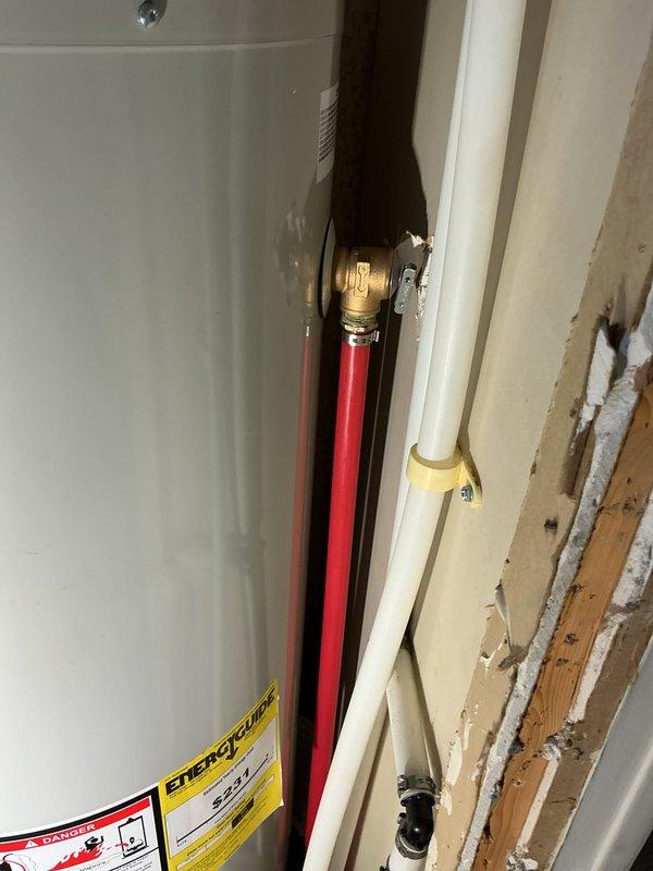 Completed warranty inspection on Bradford White residential water heater installation. Identified code violation where PEX piping was improperly used for temperature and pressure relief valve discharge line, which requires metallic piping per plumbing standards. Documented incomplete installation requiring necessary corrections including proper T&P relief valve piping, water heater platform or stand installation per code requirements, and wall access closure. Unable to perform complete inspection due to ongoing construction conditions with exposed wall framing and unfinished surfaces around installation area. Provided callback instructions for final inspection upon completion of required repairs and proper access restoration.