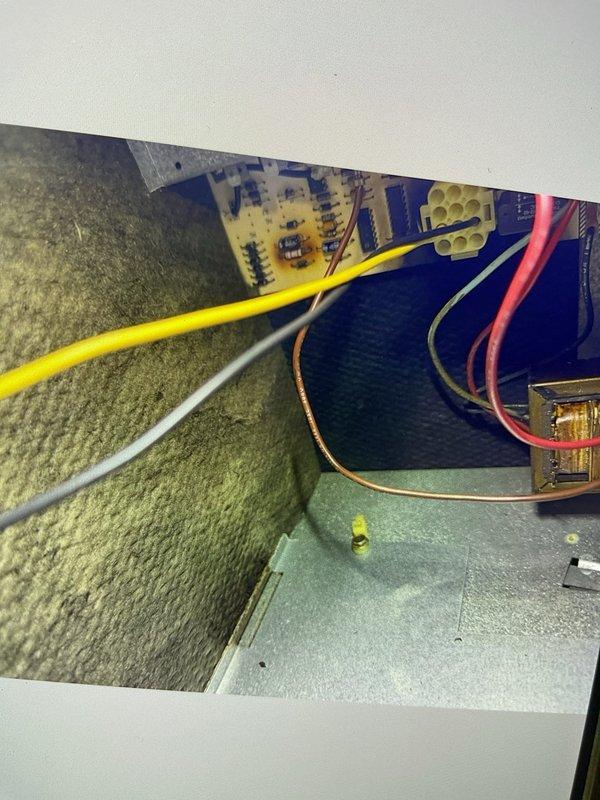 Responded to no cooling complaint on attic-mounted AC unit. Upon inspection, identified failed control board and improper wiring connections at the electrical panel. Documented existing wire routing and terminal connections with photographs showing yellow, white, orange, red, and green wires at the terminal block. Control board has been ordered and is expected to arrive Wednesday for installation. Will return to install replacement control board and correct wiring issues to restore cooling operation.