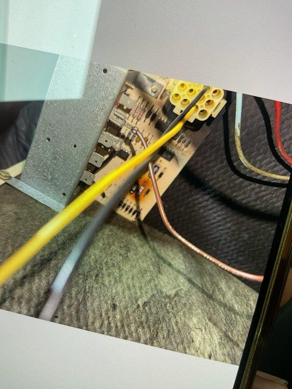 Responded to no cooling complaint on attic-mounted AC unit. Upon inspection, identified failed control board and improper wiring connections at the electrical panel. Documented existing wire routing and terminal connections with photographs showing yellow, white, orange, red, and green wires at the terminal block. Control board has been ordered and is expected to arrive Wednesday for installation. Will return to install replacement control board and correct wiring issues to restore cooling operation.