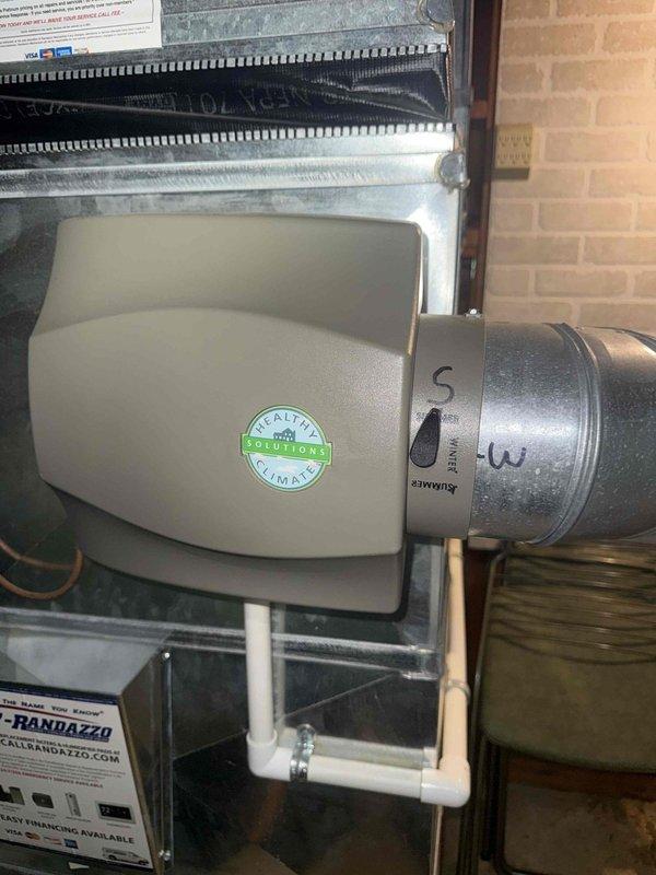 Responded to no cooling call on 12-year-old air conditioning system located in basement. Accessed property via lockbox per homeowner's instructions. Performed system diagnostics and completed requested maintenance including replacement of 16x25x5 air filter. Inspected humidifier control unit mounted on supply duct and verified proper settings and operation. Documented existing Healthy Climate humidifier installation and associated ductwork configuration. System restored to normal operation and all components functioning as designed.