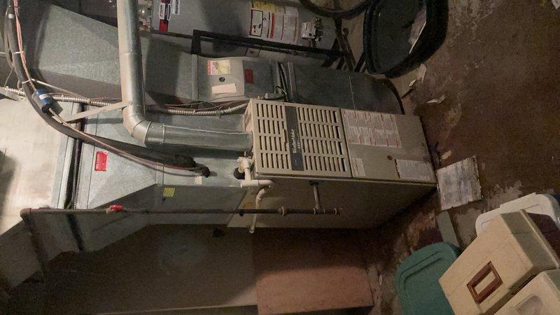 Responded to report of water leaking from bottom of furnace unit located in basement. Upon inspection, identified condensate drainage issue causing water accumulation on concrete floor around base of heating system. Cleared blocked condensate drain line, verified proper drainage flow, and confirmed no additional leaks from heat exchanger or other components. System tested and operating normally with condensate now draining properly through PVC drainage system.