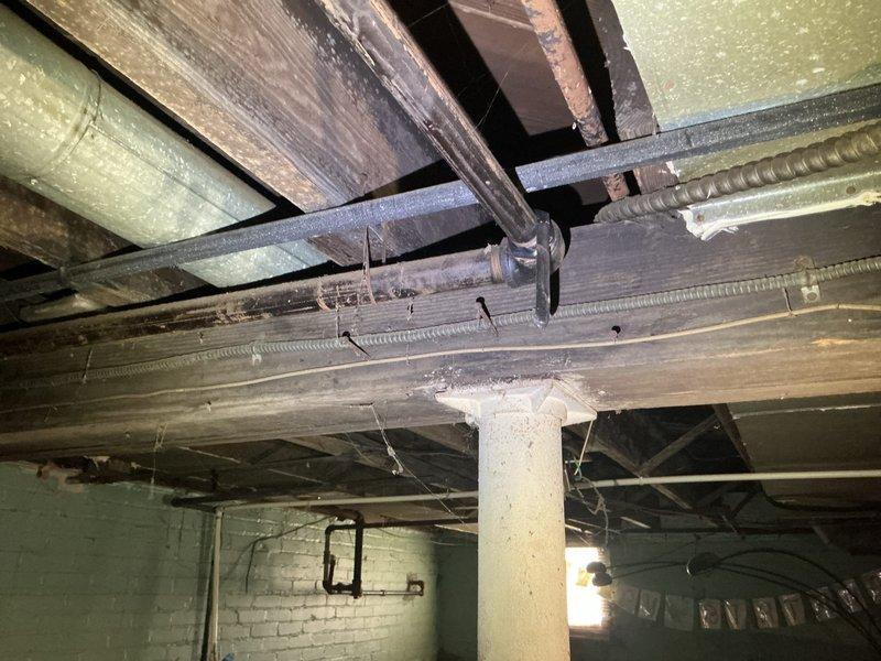 Responded to gas leak in basement affecting specific area. Located leak in dark metal gas line pipe running vertically through utility space near exposed ceiling beams and support column. Performed pressure test to isolate compromised section of gas piping. Leak had been present for approximately one week prior to service call. Repaired affected gas line section using appropriate fittings and connections, ensuring all joints were properly sealed and secured. Conducted post-repair pressure test to verify system integrity and confirm no additional leaks present. Restored gas service to affected area safely.