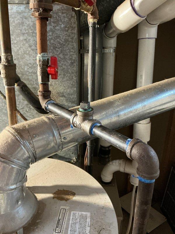Responded to homeowner report of gas leak in residential property. Upon arrival, conducted comprehensive visual inspection of gas piping system in mechanical room, identifying aging galvanized steel pipes with visible surface corrosion and multiple connection points requiring evaluation. Performed systematic pressure test on gas distribution lines to isolate and verify leak location. Inspected copper and galvanized pipe connections, fittings, and shut-off valves throughout the system, paying particular attention to corroded joints and T-fittings showing signs of deterioration. Tested all accessible gas line connections in utility area and adjacent spaces, including areas near water heater installation. System pressure test confirmed integrity of gas lines; no active leaks detected at time of inspection. Verified proper operation of existing shut-off valves. Advised homeowner that while no immediate leak was found during testing, the visible corrosion on aging galvanized pipes warrants 