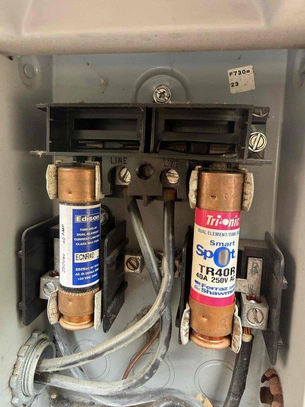 # HVAC Repair - Central Air Conditioner

Responded to service call for non-operational central air conditioning system with no heating or cooling capability. Upon arrival, performed diagnostic inspection of outdoor condensing unit and electrical components.

Inspection revealed failed dual-run capacitor preventing compressor and condenser fan motor operation. Capacitor showed visible signs of deterioration with bulging case and loss of capacitance values outside manufacturer specifications. Additionally, identified blown fuse in outdoor disconnect box, indicating electrical fault that contributed to system failure.

Removed and replaced defective 40-amp fuse in disconnect panel with new Edison-type cartridge fuse rated for 250V AC service. Disconnected power and safely discharged failed capacitor before removal. Installed new dual-run capacitor with proper microfarad ratings matching original equipment specifications for both compressor and fan motor circuits.

Verified all wire connec
