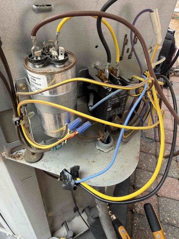 # HVAC Repair - Central Air Conditioner

Responded to service call for non-operational central air conditioning system with no heating or cooling capability. Upon arrival, performed diagnostic inspection of outdoor condensing unit and electrical components.

Inspection revealed failed dual-run capacitor preventing compressor and condenser fan motor operation. Capacitor showed visible signs of deterioration with bulging case and loss of capacitance values outside manufacturer specifications. Additionally, identified blown fuse in outdoor disconnect box, indicating electrical fault that contributed to system failure.

Removed and replaced defective 40-amp fuse in disconnect panel with new Edison-type cartridge fuse rated for 250V AC service. Disconnected power and safely discharged failed capacitor before removal. Installed new dual-run capacitor with proper microfarad ratings matching original equipment specifications for both compressor and fan motor circuits.

Verified all wire connec