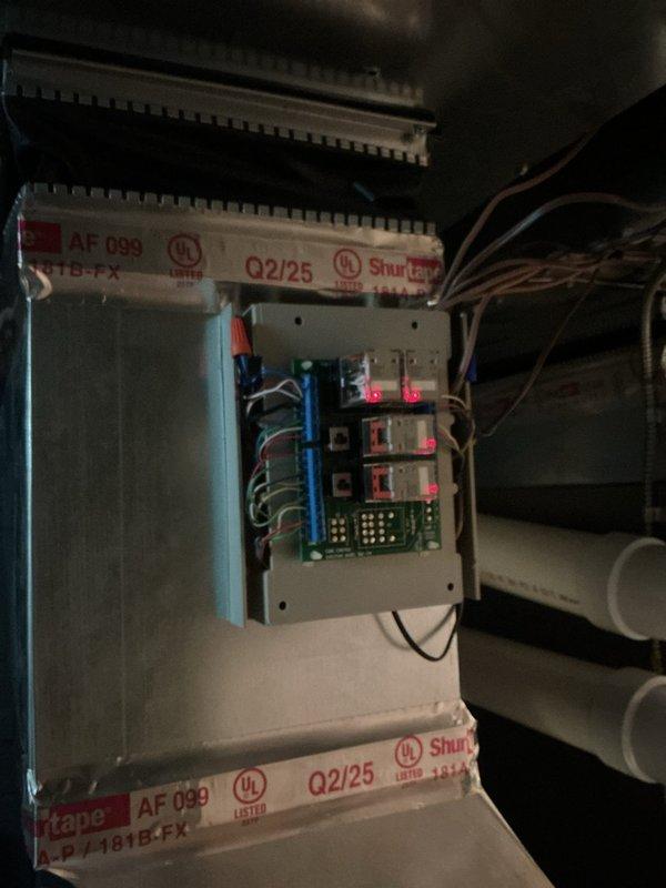 Responded to callback for multi-zone system not operating properly since previous visit. Diagnosed upstairs thermostat failure to engage air conditioning unit while main floor thermostat functioned correctly. Tested thermostat wiring by jumping terminals at upstairs location with no response from system, indicating wire failure between upstairs thermostat and zone control board. Main floor zone confirmed operational with proper cooling. Installed hard start kit on compressor to resolve startup issues, resulting in proper compressor operation and system function for main floor zone. Scheduled follow-up appointment for electrician to run new thermostat wire from upstairs location to zone board to restore full system functionality to upper level.