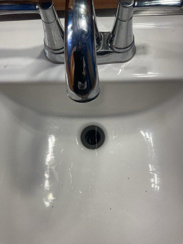 Responded to a clogged main floor bathroom sink that had been stopped up for approximately one week in a 50-year-old home. Upon arrival, respected homeowner's request for shoe covers before entering the residence. Assessed the affected fixture and determined the blockage was isolated to this sink only, with no drainage issues reported at other plumbing fixtures throughout the home.

Performed diagnostic evaluation of the bathroom sink drain system to identify the source and location of the obstruction. Removed the pop-up drain stopper assembly to access the drain opening and inspect for visible debris or buildup. Utilized appropriate drain cleaning tools to clear the blockage from the drain line, working through the P-trap and branch drain as needed to restore proper water flow.

Cleared accumulated hair, soap residue, and organic matter that had built up over time in the drain assembly and trap, which is common in bathroom sinks of this age. Ensured complete removal of all obstructing