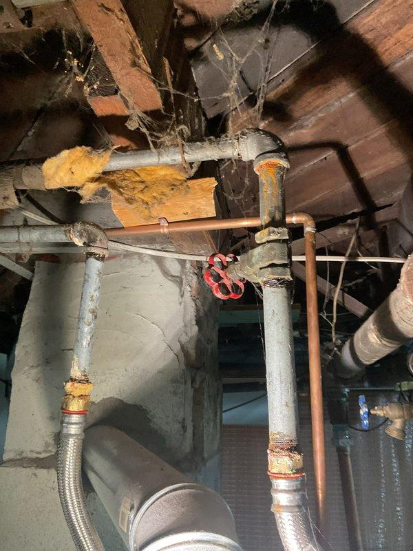 Responded to no hot water complaint affecting entire residence. Upon arrival, diagnosed water heater with no indicator light operation for three days, confirming complete loss of power to unit. Inspected basement installation revealing aging tanked water heater with corroded flexible supply connectors and deteriorating brass fittings. Assessed electrical components and determined system failure requiring immediate attention to restore hot water service to property.