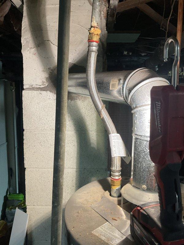 Responded to no hot water complaint affecting entire residence. Upon arrival, diagnosed water heater with no indicator light operation for three days, confirming complete loss of power to unit. Inspected basement installation revealing aging tanked water heater with corroded flexible supply connectors and deteriorating brass fittings. Assessed electrical components and determined system failure requiring immediate attention to restore hot water service to property.