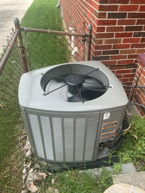 Responded to cooling complaint where indoor temperature was fluctuating between 70s and 80 degrees. Upon arrival, inspected outdoor condenser unit located on right side of residence and evaluated thermostat showing 82 degrees in cooling mode. Performed diagnostic assessment of approximately one-year-old system to determine cause of inadequate cooling performance. Documented equipment condition and thermostat operation with photos for service records.