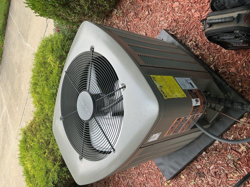 Completed comprehensive Gold AC Inspection on 1-year-old outdoor air conditioning unit located behind residence. Performed full system diagnostics including electrical measurements using digital clamp meter, recording amperage readings of 282.2A and 71.1A to verify proper compressor and fan motor operation within manufacturer specifications. Conducted visual inspection of condenser unit, confirming all components in excellent condition with clean coils, secure panels, intact protective grilles, and proper clearances from surrounding landscaping. Verified refrigerant lines properly insulated, electrical connections secure, and all manufacturer labels intact. Unit operating efficiently with no issues identified during routine maintenance check. Photographic documentation captured for service records. System ready for continued operation through cooling season.
