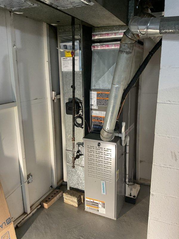 Successfully installed a 2-ton Lennox air conditioning condenser unit (Model CK40CT-24A-A71) with matching evaporator coil in residential basement location. Unit was positioned at rear of property and connected to existing furnace system with new plenum modifications to accommodate coil installation. Mechanical and electrical permits were obtained prior to installation, with electrical reconnection scheduled for licensed electrician to complete final power connection to 208-230V/1/60 service.