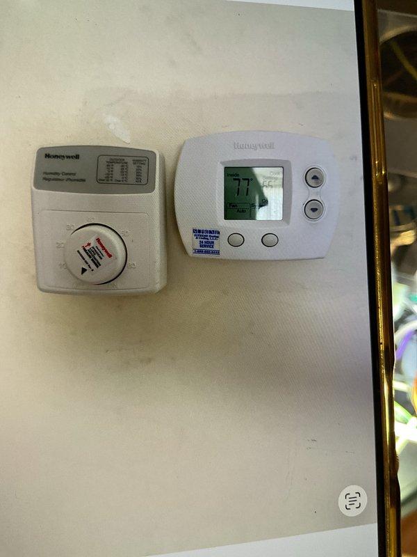 Completed comprehensive Gold AC inspection on 13-year-old residential HVAC system with air handler located in basement. Performed full system evaluation including thermostat operation verification, visual inspection of all accessible components, and photographic documentation of equipment condition. Unit found to be operational at time of inspection with Honeywell digital thermostat displaying proper cooling mode operation at 77 degrees.