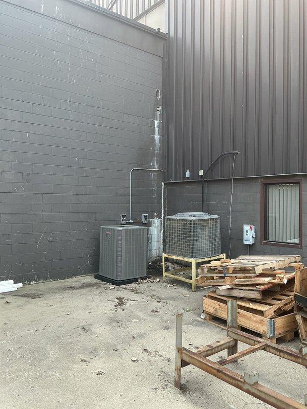 Completed a two-day complete HVAC system installation including a new furnace and air conditioning unit. Interior work included installation of furnace with flexible insulated ductwork routing, white metal supply plenum, filter housing, and ventilation components in the mechanical room. Exterior installation featured placement of outdoor condenser unit on elevated wooden platform with protective wire cage, connected via refrigerant lines to indoor equipment, with all electrical connections and startup procedures completed successfully.