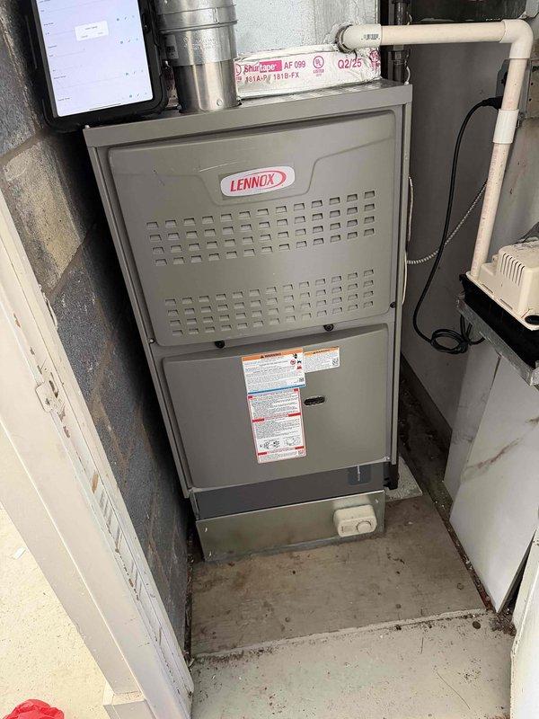 Completed Gold AC inspection on a 3-year-old Lennox system with air handler located in basement. Performed comprehensive system evaluation including filter replacement as requested. During inspection, identified significant ice buildup on refrigerant lines indicating potential low refrigerant charge, restricted airflow, or metering device malfunction. Documented equipment condition with photos showing ice accumulation on copper lines and overall system installation. System was operational at time of service but requires immediate attention to resolve icing issue and prevent compressor damage or system failure.