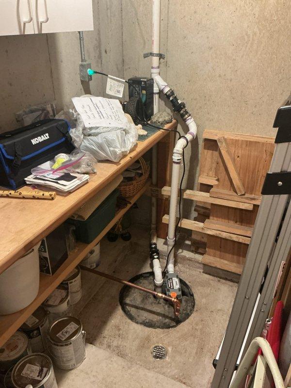 Responded to a violation notice regarding bonded hot water heater installation. Upon arrival, inspected exposed plumbing infrastructure within wall cavity and basement utility area. Documented existing plumbing configuration including white PVC drainage assembly with multiple elbows and joints running vertically through framing, copper supply lines with chrome shut-off valves, and galvanized steel piping. Verified sump pump basin installation with associated PVC discharge piping system. Photographed all plumbing connections, valve locations, and mechanical chase conditions for compliance documentation and warranty record purposes.