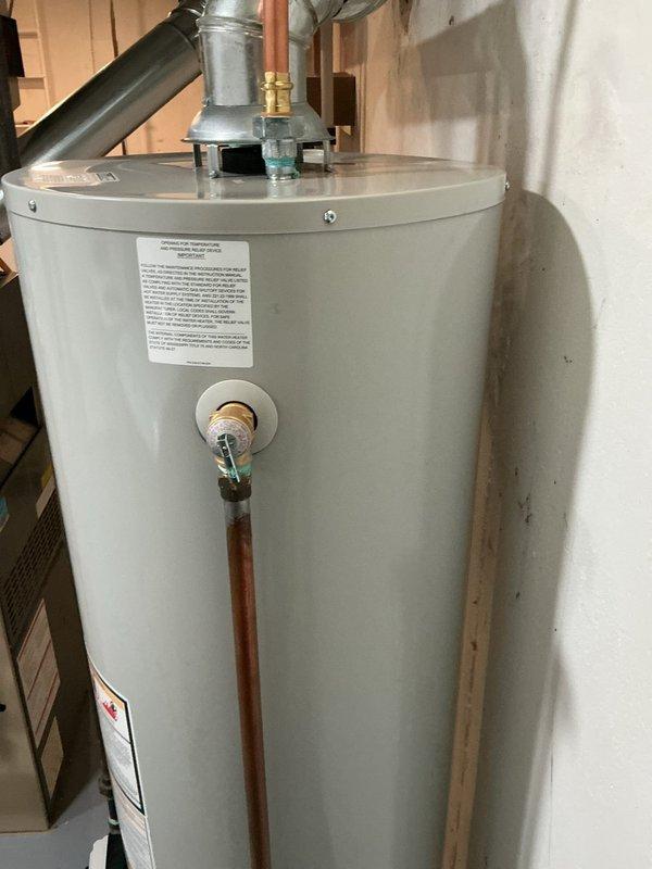 Completed warranty replacement of a damaged 40-gallon Bradford White tanked water heater. Removed and disposed of the dented unit, then installed new Bradford White 40-gallon gas-fired water heater in basement utility room. Connected copper supply lines with dielectric unions at hot and cold water connections, installed gas supply line with shut-off valve, and properly vented unit through existing ductwork. Installed temperature and pressure relief valve with discharge tube terminating near floor level per code requirements. System tested for proper operation, gas leaks, and water connections verified leak-free.