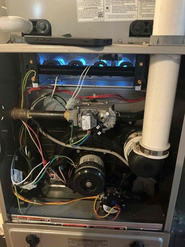Completed comprehensive tune-up and city certification inspection on residential gas furnace system. Performed thorough inspection of all internal components including burner assembly with confirmed proper flame operation across all four burners, gas valve assembly with verified electrical connections, blower motor assembly, and PVC venting system. Inspected and evaluated thermostat operation, humidifier functionality, and hot water tank condition including pressure relief valve and copper supply lines. All systems found operating within normal parameters and documented with photographs for certification records.