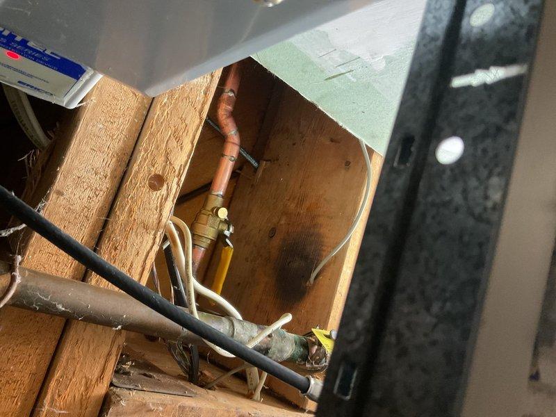 Coordinated with city utility department for water main shutoff to perform front foundation hose bib and water meter repairs. Accessed plumbing infrastructure through ceiling cavity, replacing damaged copper piping, brass valve assemblies, and associated fittings. Installed new hose bib connection with proper shutoff valves and reconnected meter assembly using code-compliant copper and PVC pipe transitions within wooden framing structure.