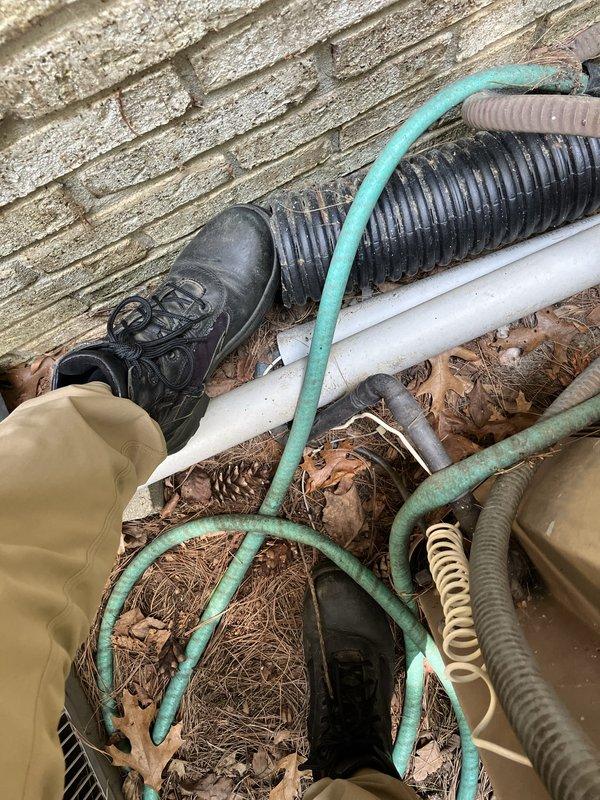 Conducted comprehensive HVAC system assessment for complete air conditioning and furnace replacement with Bryant equipment as specified by customer. Evaluated existing basement-installed furnace unit with metal ductwork and galvanized steel components, noting age and dust accumulation indicating end of service life. Documented exterior utility area including refrigerant lines, condensate drainage, and associated piping configuration to determine replacement requirements and ensure proper system sizing for full Bryant system installation.
