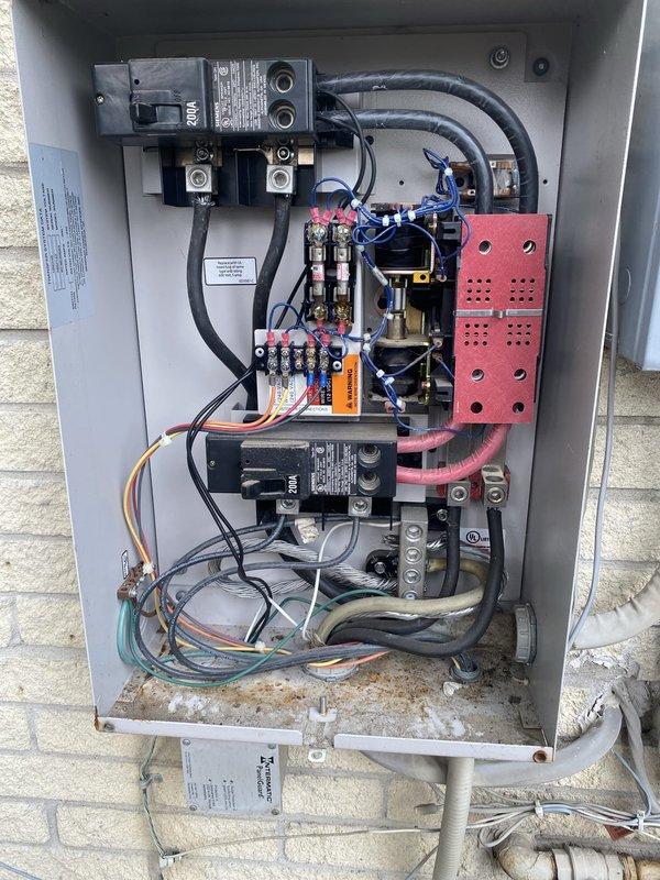 Completed full residential generator installation including electrical hookup, gas piping with pressure testing, and automatic transfer switch integration. Installed and wired transfer switch panel with dual disconnect breakers, contactors, and multi-circuit wiring distribution for seamless power transfer between utility and generator sources. Ran and connected natural gas supply line with appropriate shutoff valves and fittings to fuel the generator unit. Performed pressure testing on all gas piping to verify system integrity and code compliance. All electrical connections terminated per manufacturer specifications with proper wire sizing and color coding for phase identification. Transfer switch mounted in weatherproof enclosure on exterior wall with complete integration to existing electrical service panel. System tested and verified operational for automatic startup and power transfer functionality.