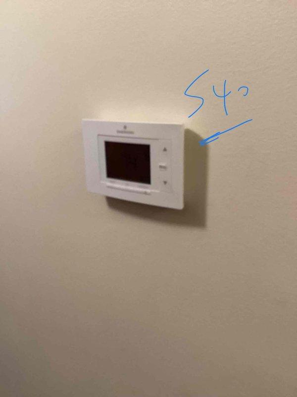Conducted comprehensive on-site evaluation for full HVAC system replacement, including furnace and air conditioning unit. Assessed existing thermostat configuration, currently displaying 54°F setpoint on programmable digital control mounted in living space. Inspected installation area in basement/workshop location, documenting existing mechanical infrastructure including overhead ductwork, ventilation systems, and available workspace for equipment placement. Photographed current thermostat and proposed equipment installation area to facilitate accurate system sizing and replacement planning. Provided detailed quotation for complete heating and cooling system replacement based on home's specific requirements and existing infrastructure layout.