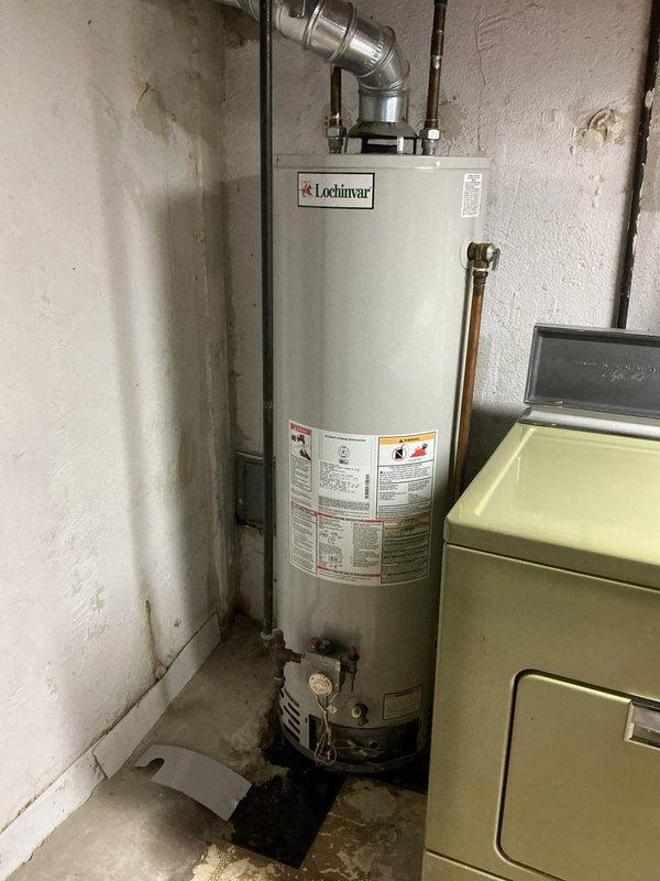 Responded to service call for water heater leaking from bottom in basement utility area. Upon inspection, determined existing Lochinvar unit had failed tank integrity and required full replacement. Removed old water heater and disconnected all plumbing connections and venting. Installed new Bradford White tanked water heater with proper venting through existing exhaust system. Connected copper supply lines, installed new shutoff valves, and ensured all connections were secure and leak-free. Tested unit for proper operation, verified temperature and pressure relief valve functionality, and confirmed no leaks at any connection points. System restored to full operation.