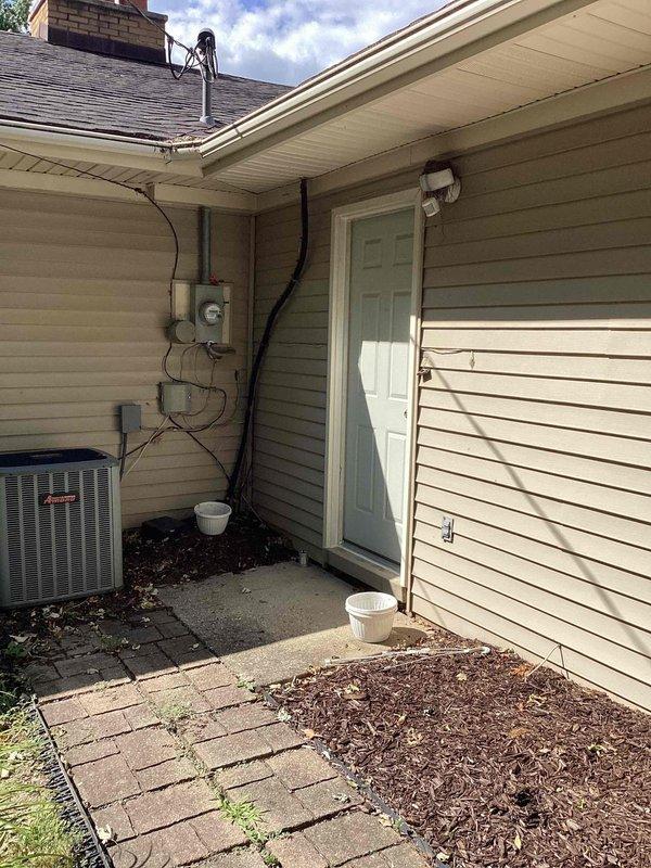 Conducted site evaluation for Kohler generator installation at residential property. Assessed electrical panel location in mud room adjacent to garage and evaluated exterior placement options for generator unit. Documented existing electrical infrastructure, including current HVAC condenser positioning and electrical service entry point on exterior wall. Reviewed available space considerations for generator pad installation, electrical conduit routing from panel to generator location, and compliance requirements for clearances from building structures and existing mechanical equipment.