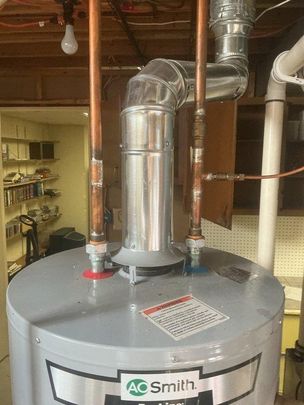 Completed comprehensive HVAC tune-up inspection on heating system over 10 years old, including thorough examination of humidifier, thermostat, and hot water tank components. Inspected A.O. Smith 50-gallon natural gas water heater (Model GCG-50 400, manufactured 03/30/2017) with 40,000 BTU/HR input rating, verifying proper operation of gas connections, copper supply lines with shutoff valves, and venting system. All equipment found operating within normal parameters with no immediate service requirements identified.