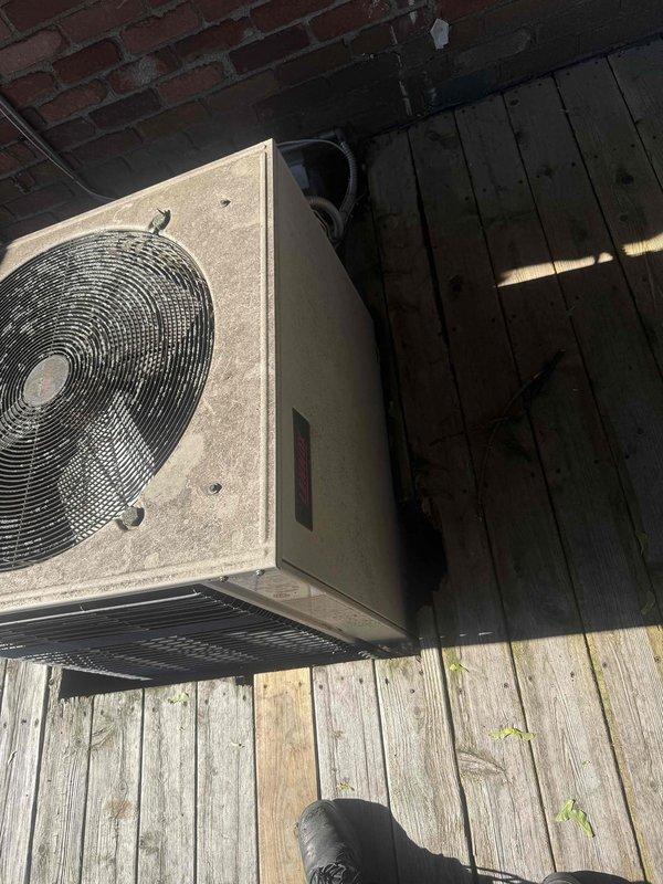 Completed comprehensive AC inspection and enrolled customer in Gold plan membership on-site. Performed full system evaluation of outdoor condenser unit located on deck, including inspection of humidifier, thermostat, and hot water tank as specified. Documented visible heat damage and soot accumulation on front access panel of condenser unit requiring further assessment, along with general weathering and dirt buildup on exterior cabinet. Verified refrigerant line insulation integrity and captured photographic documentation of unit condition for service records.