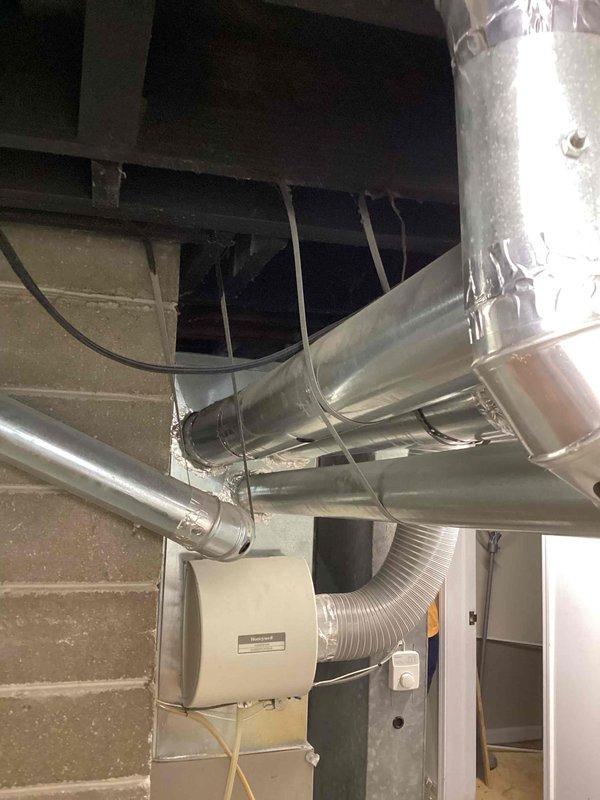 Conducted comprehensive site assessment for full HVAC system upgrade at residential property. Customer currently has gas-fired forced air heating system with existing ductwork infrastructure and humidifier in place, seeking to add central air conditioning and evaluate furnace replacement needs. Inspected existing basement mechanical room setup, documenting current ductwork configuration including main trunk lines, flexible connections, and humidification equipment. Evaluated exterior utility connections and electrical service capacity at meter location to determine adequacy for additional AC condenser unit installation. Assessed duct system integrity and sizing to confirm compatibility with proposed cooling system addition. Photographed existing equipment layout, electrical infrastructure, and available mounting locations for outdoor condensing unit. Provided recommendations for AC installation options and furnished replacement considerations based on current heating system condition a