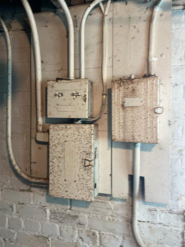 Performed comprehensive electrical system assessment of residential property with original fuse panel and wiring. Evaluated existing six-fuse panel configuration and determined inadequate amperage capacity for air conditioning unit, which was experiencing circuit overload issues on 15-amp fused circuit. Inspected grounded outlet system and aging electrical infrastructure including multiple junction boxes and conduit runs showing signs of environmental exposure and deterioration. Provided detailed estimate for complete electrical service upgrade including replacement of obsolete fuse panel with modern circuit breaker panel and installation of dedicated 240-volt circuit with appropriate amperage capacity and exterior outlet for air conditioning unit to meet current electrical code requirements and equipment specifications.
