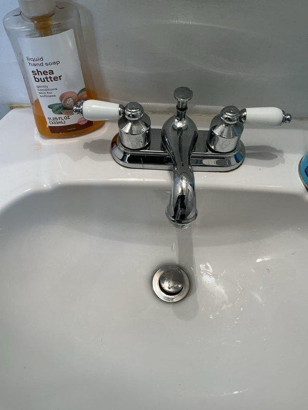Responded to service call for non-functioning hot water side of bathroom sink faucet in 26-year-old home. Upon inspection, diagnosed failed hot water cartridge in the affected handle of the two-handle chrome faucet assembly. Shut off water supply at angle stop valve beneath sink, removed defective hot water handle and cartridge, and installed replacement cartridge compatible with existing faucet model. Reassembled handle assembly with white porcelain accent trim, restored water supply, and tested both hot and cold water flow to verify proper operation and absence of leaks. Confirmed no other plumbing fixtures were affected and that issue was isolated to single faucet cartridge failure, eliminating need for complete faucet replacement at this time.