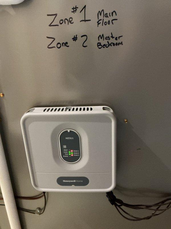 Returned to site with replacement Honeywell HZ311 zone control board and non-programmable thermostats to complete rewiring and resolve previous system issues. Successfully installed and wired new zone board to control two-zone HVAC system serving main floor (Zone 1) and master bedroom (Zone 2), verified all zone dampers operating correctly, and confirmed proper system operation with cooling restored to both zones.