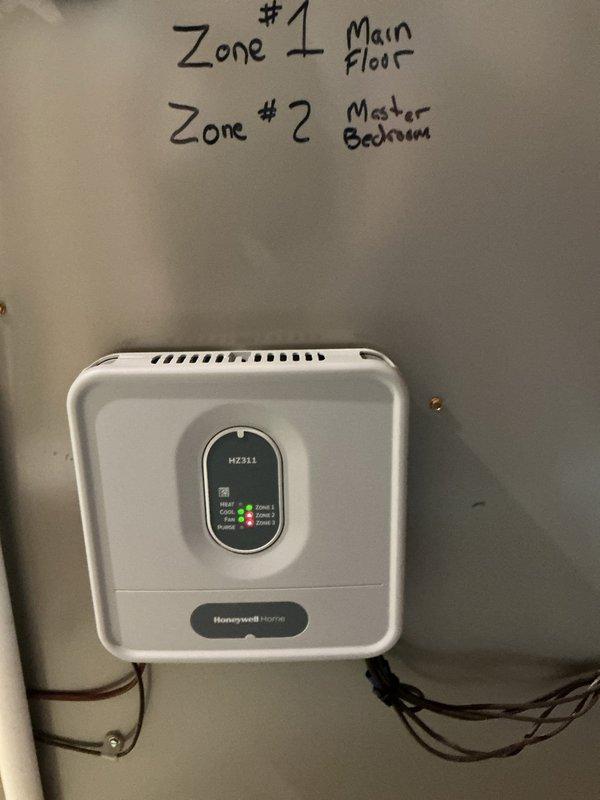 Returned to site with replacement Honeywell HZ311 zone control board and non-programmable thermostats to complete rewiring and resolve previous system issues. Successfully installed and wired new zone board to control two-zone HVAC system serving main floor (Zone 1) and master bedroom (Zone 2), verified all zone dampers operating correctly, and confirmed proper system operation with cooling restored to both zones.