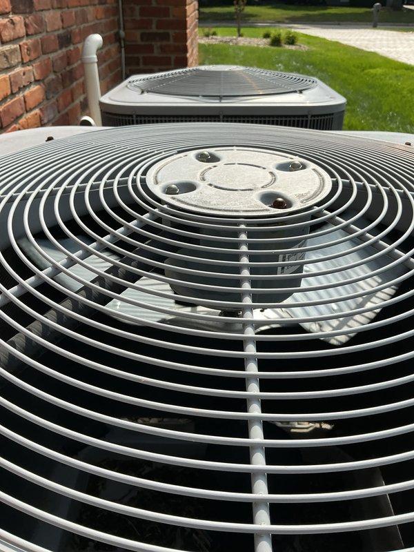 Completed comprehensive Gold AC inspection on residential property with two outdoor condenser units and multiple indoor units including attic-mounted air handler and basement boiler system. Performed visual inspection of both outdoor condensers positioned on concrete pad, confirming units in good operational condition with clean fan grilles, intact protective guards, and no visible damage or deterioration to exterior components. Inspected electrical contactor assembly, verifying proper wire connections across all phases with yellow, black, red, and blue conductors securely terminated at contact blocks. Documented system configuration with mini-split components distributed throughout home. All equipment confirmed operational at time of inspection with no immediate service needs identified.