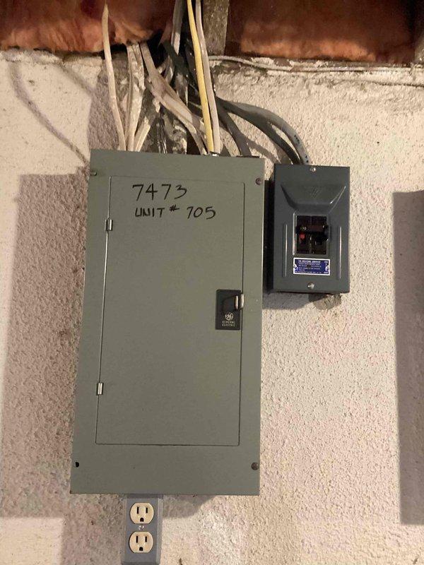 Provided estimate for complete air conditioning system replacement at condominium unit with outdoor condenser and indoor air handler located in laundry area. Existing equipment operational but aged beyond serviceable life, with natural gas furnace infrastructure in place. Assessed electrical panel capacity and outdoor installation space, documented current system configuration including conduit routing and utility connections to prepare comprehensive replacement proposal.
