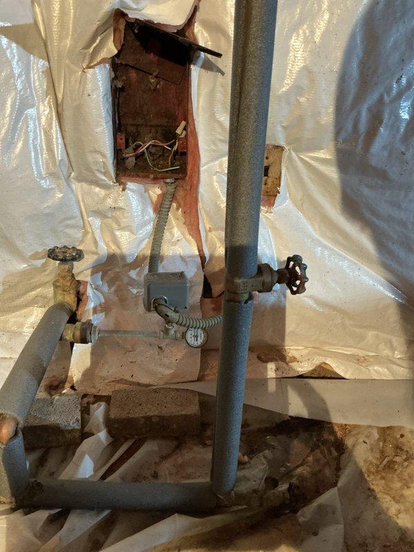 Responded to a whole-house low water pressure issue that had persisted for three days. Upon inspection, diagnosed a failing pressure tank system in the crawl space. The existing turquoise Well-Rite pressure tank showed signs of waterlogging and loss of air charge, preventing proper pressure regulation throughout the home. Inspected the associated plumbing assembly, including the main shutoff valve with black wheel handle, pressure switch, and connecting piping. Found corroded fittings and compromised connections contributing to system inefficiency. Tested pressure readings at the tank and verified inadequate pressure maintenance. Explained findings to homeowner, including the need for pressure tank replacement and potential valve assembly updates to restore proper water pressure throughout the residence. Documented existing conditions with photographs for reference and provided recommendations for complete system restoration.