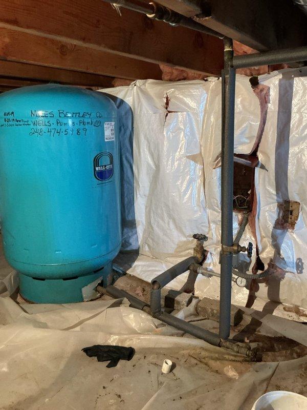 Responded to a whole-house low water pressure issue that had persisted for three days. Upon inspection, diagnosed a failing pressure tank system in the crawl space. The existing turquoise Well-Rite pressure tank showed signs of waterlogging and loss of air charge, preventing proper pressure regulation throughout the home. Inspected the associated plumbing assembly, including the main shutoff valve with black wheel handle, pressure switch, and connecting piping. Found corroded fittings and compromised connections contributing to system inefficiency. Tested pressure readings at the tank and verified inadequate pressure maintenance. Explained findings to homeowner, including the need for pressure tank replacement and potential valve assembly updates to restore proper water pressure throughout the residence. Documented existing conditions with photographs for reference and provided recommendations for complete system restoration.
