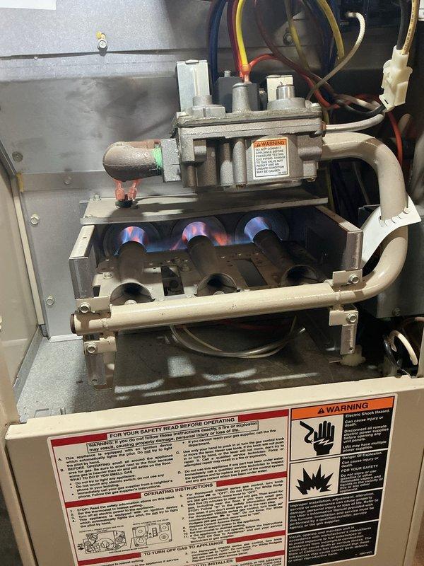 Replaced blower motor assembly on Lennox unit under purchase order 1351332-001. Upon inspection, found existing blower wheel heavily caked with dust, lint, and debris accumulation that had completely obscured fan blades and restricted airflow. Removed old motor assembly, cleaned housing compartment, and installed new blower motor with clean squirrel cage fan. Verified all electrical connections including ground wire and multi-colored lead wires were properly secured. Tested unit operation and confirmed burner assembly ignition with proper blue flame pattern across all three burners. Gas valve and associated connection lines inspected and found in good working order. Unit cycling properly and delivering adequate airflow upon completion.