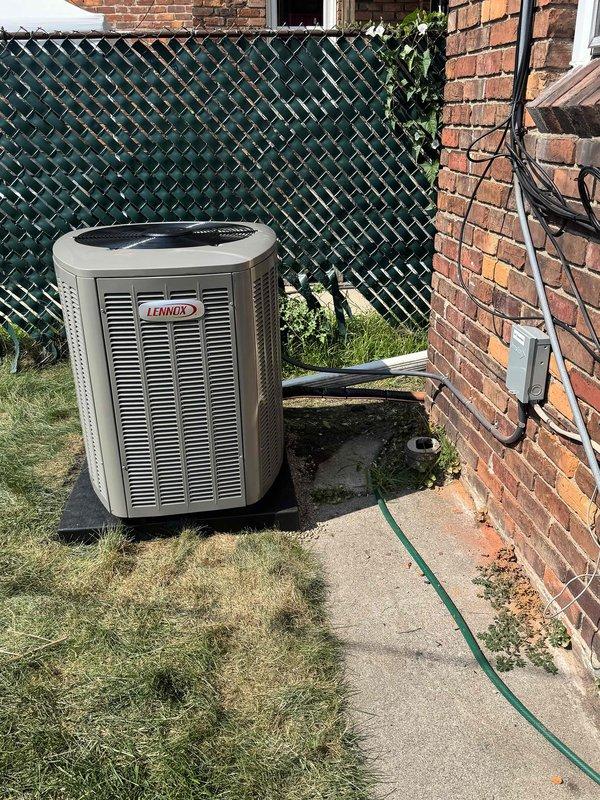 Completed installation of 3-ton Lennox air conditioning condenser unit with matching evaporator coil at rear of residence. Unit was positioned on concrete pad against brick exterior wall, with electrical disconnect box mounted and conduit properly run for power connection. All mechanical and electrical permits were requested and reconnection of existing electrical service was completed to manufacturer specifications.