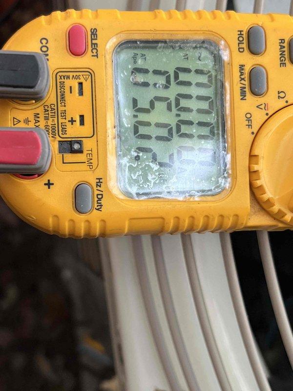 Performed comprehensive Gold Plan maintenance inspection on 26-year-old residential air conditioning system located at exterior front of property. Conducted complete system evaluation including visual inspection of outdoor condenser unit, which showed age-appropriate wear but remained in functional condition. Unit positioned on gravel bed against brick wall with adequate clearance for airflow.

Executed full preventive maintenance protocol including inspection of condenser coils through protective wire grille, verified fan operation and examined top housing assembly. Utilized digital multimeter to perform electrical diagnostics, testing voltage and amperage readings to ensure system operating within manufacturer specifications. Assessed refrigerant lines, electrical connections, and condensate drainage. Verified proper compressor operation and measured system performance parameters.

Documented equipment condition through photographic records showing overall unit placement, surrounding