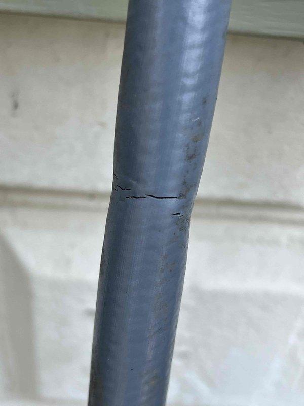 Completed comprehensive Gold AC Inspection on 10-year-old air conditioning system with no reported issues. Performed standard tune-up procedures including electrical testing with multimeter, which showed normal voltage readings at 33.52V. During inspection, identified a horizontal crack in the condensate drain line PVC pipe requiring attention to prevent future water damage or drainage issues.