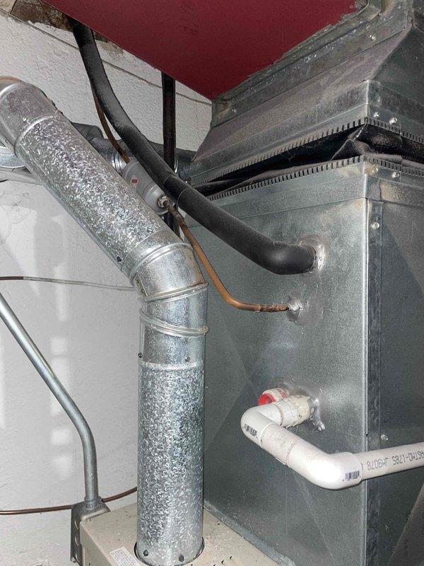 Performed comprehensive evaluation of 15-year-old air conditioning system with complete loss of cooling capacity affecting entire residence. Assessed outdoor condensing unit located behind property, inspected indoor air handler and furnace assembly in basement utility area, and evaluated electrical panel and associated connections. Documented existing equipment configuration including ductwork, condensate drainage system, and electrical infrastructure. Provided detailed replacement estimate for complete HVAC system upgrade due to age and condition of existing equipment.
