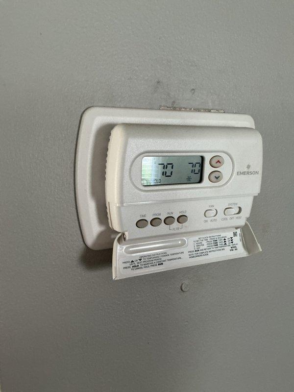 Completed comprehensive Gold AC inspection on 4-year-old air conditioning system located in basement mechanical room. Performed full system evaluation including visual inspection of HVAC unit, ductwork connections, refrigerant lines, and electrical components. Verified thermostat operation and programming functionality on Emerson programmable unit, confirming proper temperature control and system communication. Inspected condensate drainage, air handler components, and all accessible mechanical connections. System found to be operating within normal parameters with no immediate service needs identified. All equipment components visually assessed and documented through photographic records showing furnace assembly, copper refrigerant piping, ductwork, and control systems in satisfactory working condition.