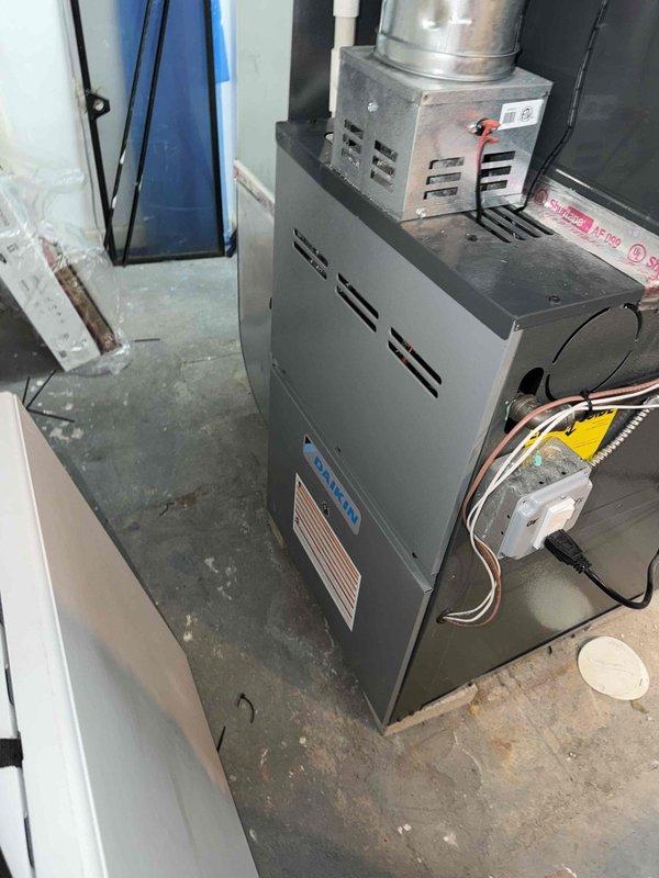 Responded to customer complaint of loud vibrating noise occurring when air conditioning unit cycles off. Upon inspection of the three-year-old basement AC system, performed diagnostic evaluation of the blower motor assembly and associated components. System was found to be cooling adequately despite the noise concern. Inspected furnace unit, ductwork connections, and electrical components for loose mounting hardware or mechanical issues that could cause vibration during compressor shutdown. Documented equipment condition with photographs showing HVAC unit installation, blower motor assembly, and surrounding mechanical components. Advised customer of findings and provided recommendations for addressing the vibration issue during the shutdown cycle.