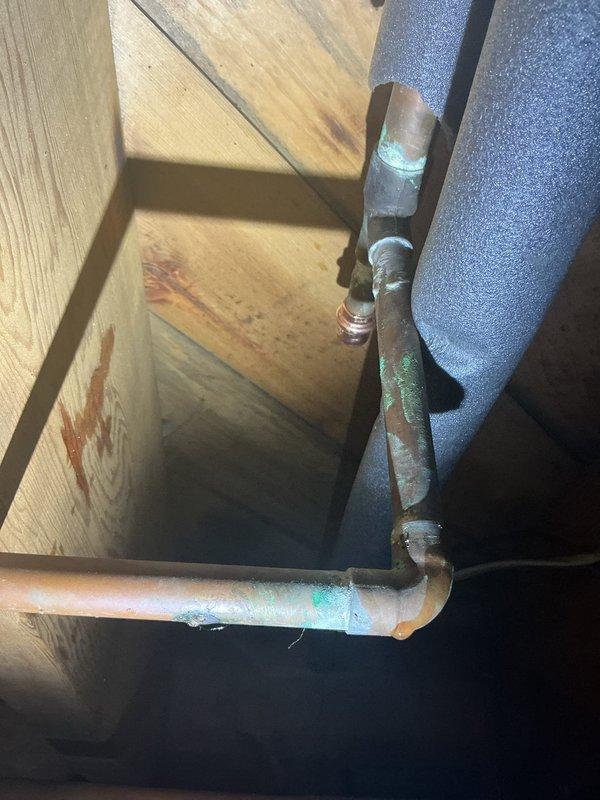 # Plumbing Service Completed

Responded to service call for corroded copper refrigerant lines on exterior HVAC system. Upon inspection, identified significant copper oxidation and verdigris formation at multiple soldered joints and along exposed pipe surfaces, indicating prolonged moisture exposure. Replaced deteriorated copper line set with new refrigerant-grade copper piping, ensuring proper brazing techniques and leak-free connections.

Additionally addressed plumbing issue in attic space where copper water supply line showed signs of leakage contributing to moisture damage on surrounding wooden joists and subflooring. Installed new brass shutoff valve on copper supply line and secured proper foam insulation to prevent future condensation issues. Verified no active leaks present after installation and confirmed adequate ventilation in attic space to minimize future moisture accumulation and mold growth on structural components.